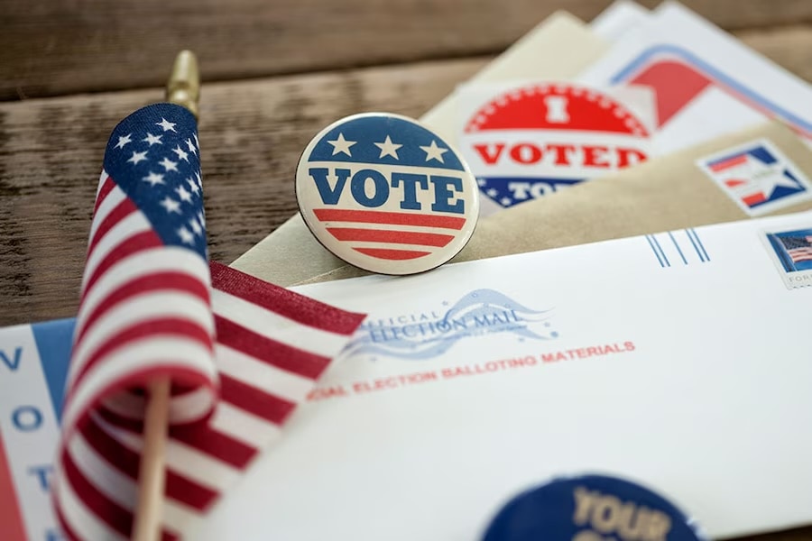 Mini American flag next to voting materials.